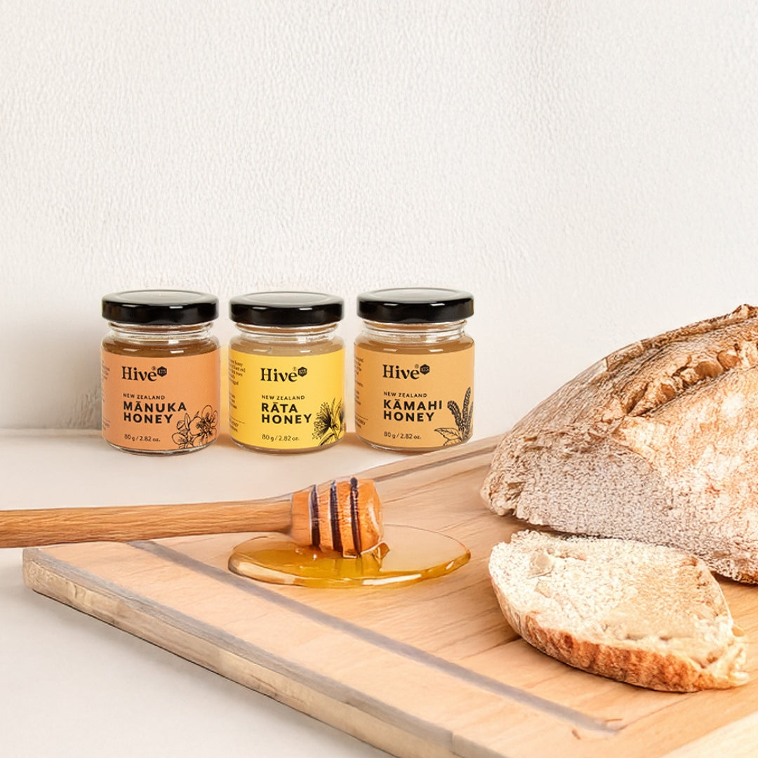 Jars of Hive 175 New Zealand honeys on a kitchen counter with sliced fresh bread